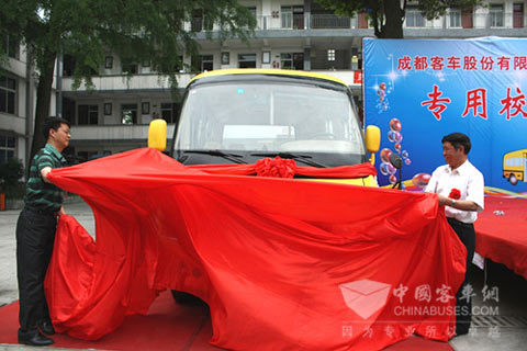 成客股份公司董事长王容坤同甘波校长一起为捐赠的专用校车揭幕